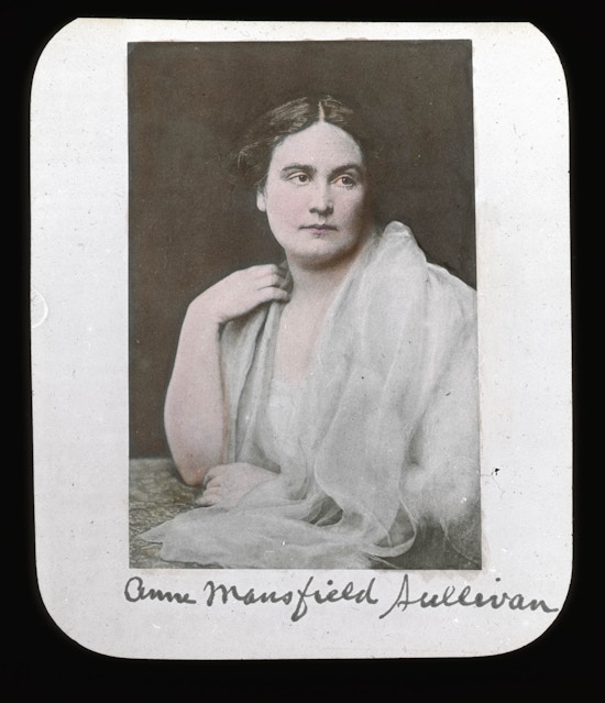 Portrait of Anne Sullivan, seated, wearing all white, head facing right with body turned left.