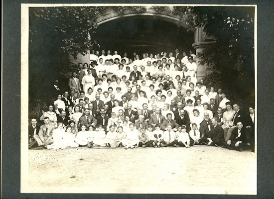 Large black and white group photo taken under an archway of the American Association to Promote Teaching Speech to the Deaf Summer Meeting in 1908.