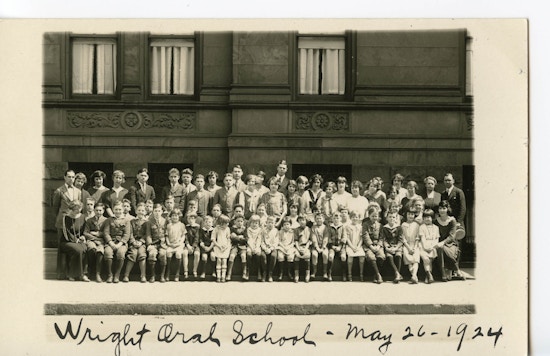 Group portrait of students and teachers posed outside the Wright Oral School.