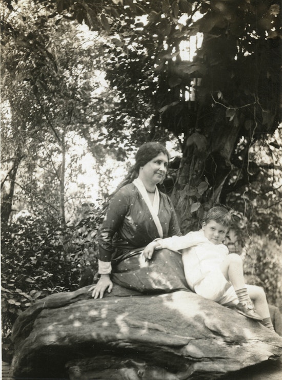 Helen Keller and young Jack Wright under a large tree in Mr. Wright's garden.
