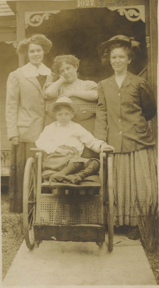Three women with little boy in a wheelchair.