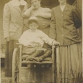 Three women with little boy in a wheelchair.