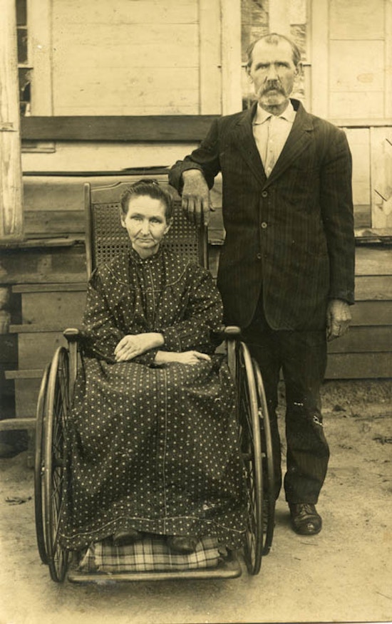 Elderly Man And Woman With Wheelchair,  Woman dressed in long dress.