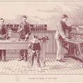 Four men and one boy in suits, in a piano tuning shop.