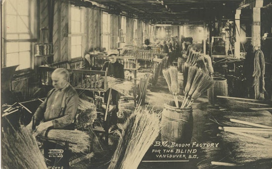 Men on benches making brooms by hand.