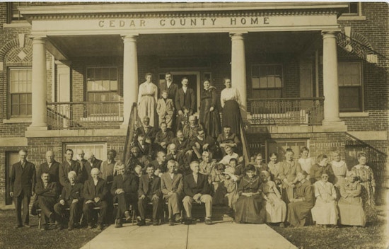 Group photo of men and women on steps of building.