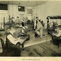 Six men working in a typesetting room.