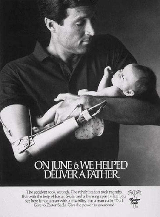A man with a prosthetic right arm cradles a baby.