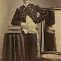 Henry Barnum in uniform.  His coat and shirt are pulled aside from his left hip revealing a wound through which a string passes.