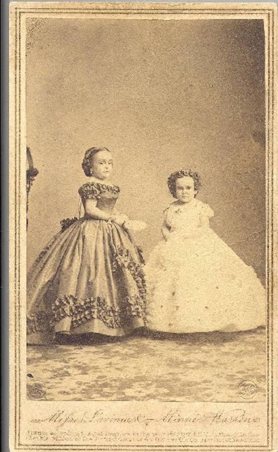 Two short-statured women, both formally dressed.