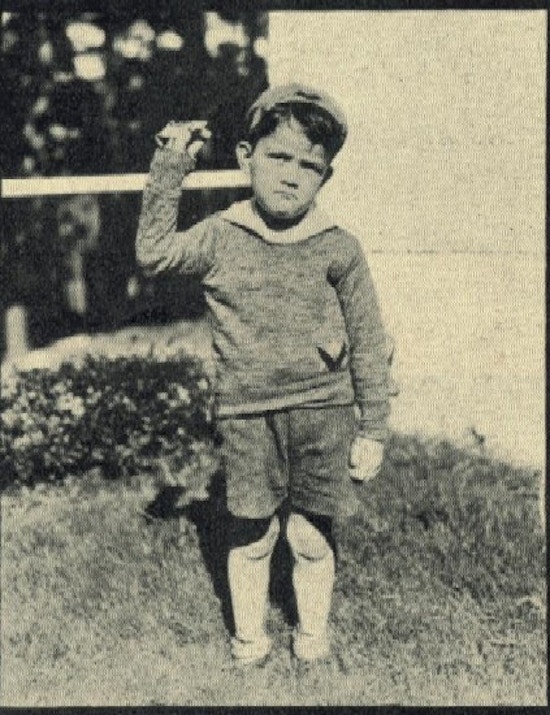 A boy holds up one arm.