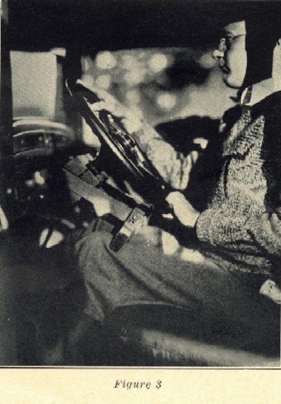 A man sits at a steering wheel.