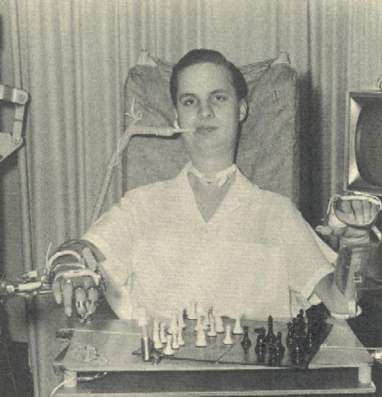 A young man plays chess with assitive technology.