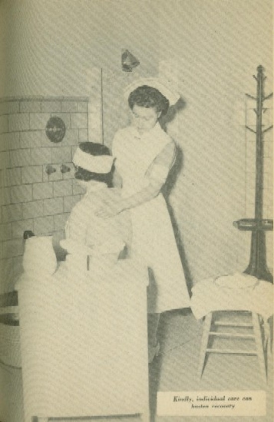 A nurse dressed in white washes a woman's back.