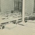 An institutional room room crowded with beds.