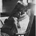 A woman in rocking chair holding child.