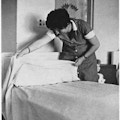 A woman making a bed.