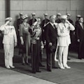 King George, Franklin Roosevelt, Eleanor Roosevelt stand with military personnel, many saluting, at Union Station.