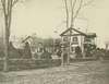 A large house with fence and elm trees.