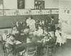 A teacher supervises a classroom with eleven children.