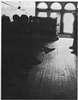 People sitting on a bench in a room.