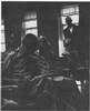 Men on a ward, one stands near a window.