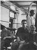 Men in a ward, one slouching in a chair,