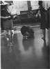 Women on a ward, one parially dressed, one cared a large stuffed animal, another curled up on the floor.