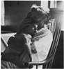 A woman in rocking chair holding child.