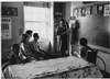 A teacher with four children in a classroom.