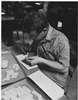 A young man gluing paper.