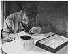 A young man cutting paper.