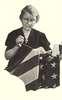 An elderly woman sewing an American flag.