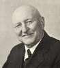 Portrait of Edar J. Helms, an elderly balding man with glasses.