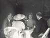 Franklin Roosevelt and the royal couple sit at a table on the porch of Top Cottage.