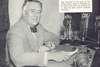 FDR sits at desk with CBS and NBC radio microphones.