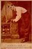Sepia toned photo of man hunched over holding a cane.