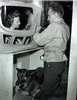Woman and blind man work on aircraft as his seeing eye dog lies at his feet
