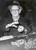 Elderly man with glasses prepares to palm screw.