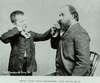 A teacher helps his young deaf student to recognize a sound placing the boys finger along side his nose.