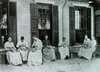 Group of epilepsy patients paring vegetables outside a building at the Craig Colony.