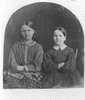 Two women pose with their arms crossed against their chests