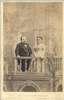 Full frontal view of Mr. and Mrs. Thumb standing on a balcony.