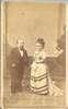A short-statured man and woman, both formally dressed.