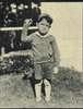 A boy holds up one arm.