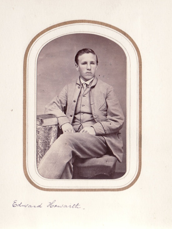 Edward Howarth, seated portrait, light suit, legs crossed.