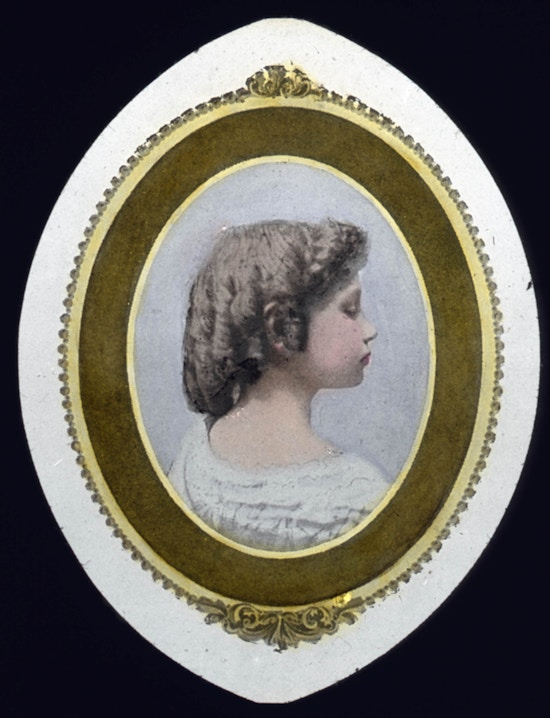 Color portrait of child Helen Keller with her hair in ringlets facing profile side right.