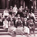 Bell with a group of children sitting on steps.