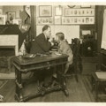 John Wright (left) examining a child at desk in an office.