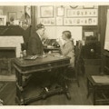 John Wright (left) examining a child at desk in an office.